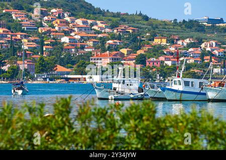 Capodistria, Slovenia - 25 agosto 2024: Barche nel porto di Capodistria, circondate da pittoresche case sulla costa *** Boote im Hafen von Koper, umgeben von malerischen Häusern an der Küste Foto Stock