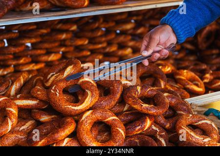 Il venditore porta Fresh simitis al banco in Turchia Foto Stock