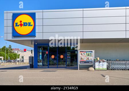 Capodistria, Slovenia - 25 agosto 2024: Negozio Lidl a Capodistria, Slovenia, con architettura moderna e area shopping cart *** Lidl-Filiale a Capodistria, Slowenien, mit moderner Architektur und Einkaufswagenbereich Foto Stock