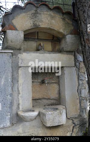 Vecchia fontana di pietra nella campagna per il cretese Foto Stock