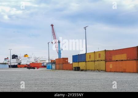 Container merci, gru e una nave nel porto merci industriale di Mukran sull'isola di Rugen nel Mar Baltico, in Germania, cielo nuvoloso con spazio di copia, selec Foto Stock