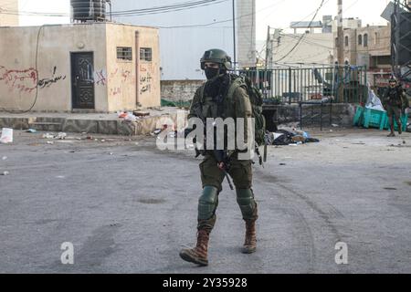 Tubas, Palestina. 11 settembre 2024. Un soldato di fanteria israeliano ha visto schierarsi nella città di Tubas durante il raid. Un raid militare israeliano su larga scala nella città di Tubas, nella Cisgiordania occupata a nord, dove cinque palestinesi sono stati uccisi in un attacco aereo e le forze hanno circondato un ospedale palestinese e impedito al personale medico di trasportare pazienti. (Foto di Nasser Ishtayeh/SOPA Images/Sipa USA) credito: SIPA USA/Alamy Live News Foto Stock