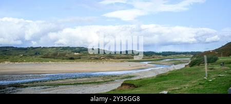 Il passaggio finale del fiume Ogmore (Afon Ogwr) fino al punto in cui entra nel Canale di Bristol. Nascondere la marea ritirandosi; tardo pomeriggio; tarda estate. Foto Stock