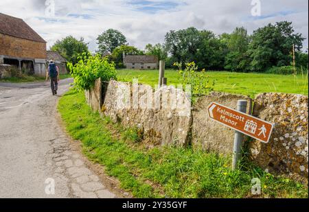 Walker su una corsia che conduce al Tamigi Path a Kelmscott Manor ex casa di William Morris Oxfordshire UK Foto Stock