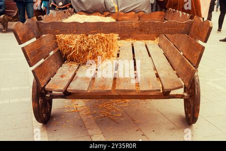 un vecchio carrello di legno si trova nel cortile Foto Stock