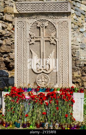 Khachkar armeno nel cortile della cattedrale armena in rovina di San Nicola. Fiori e candele per l'anniversario del genocidio armeno. Foto Stock