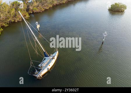 Yacht a vela mezzo sommerso si capovolse in acque poco profonde della baia dopo l'uragano Ian a Manasota, Florida. Foto Stock