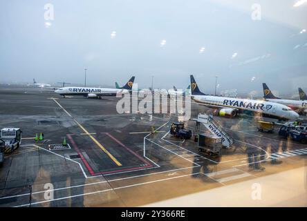 I viaggiatori delle compagnie aeree si riflettono sulla finestra, mentre fanno la coda per un volo Ryanair all'aeroporto di Dublino, Irlanda. Foto Stock