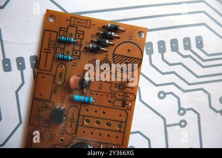 Scheda elettronica con simboli dei componenti elettronici su una parte degli schemi stampati del quadro elettrico Foto Stock