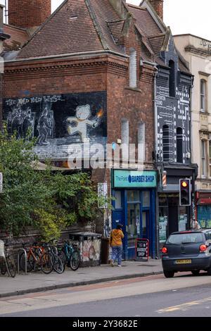 Il lavoro di Banksy The Mild Mild West sul lato di un barbiere a Stokes Croft, Bristol Foto Stock