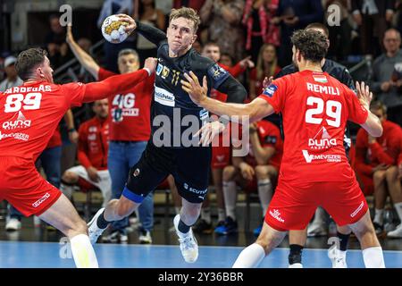 Berlino, Germania. 12 settembre 2024. Pallamano: Champions League, Füchse Berlin - Telekom Veszprem, fase A gironi, gruppo A, giornata 1, Max-Schmeling-Halle. Lasse Andersson (centro) di Berlino lancia il pallone in porta contro Ludovic Fabregas (sinistra) e Nedim Remili del Veszprem KC. Crediti: Andreas Gora/dpa/Alamy Live News Foto Stock