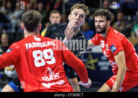 Berlino, Germania. 12 settembre 2024. Pallamano: Champions League, Füchse Berlin - Telekom Veszprem, fase A gironi, gruppo A, giornata 1, Max-Schmeling-Halle. Lasse Andersson (centro) di Berlino lancia il pallone in porta contro Ludovic Fabregas (sinistra) e Nedim Remili del Veszprem KC. Crediti: Andreas Gora/dpa/Alamy Live News Foto Stock