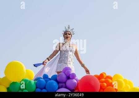 Goiânia GOIAS BRASILE - 08 SETTEMBRE 2024: Una persona LGBT, vestita di bianco con un galleggiante decorato con palloncini, ballando, alla LGBT Pride Parad del 2024 Foto Stock