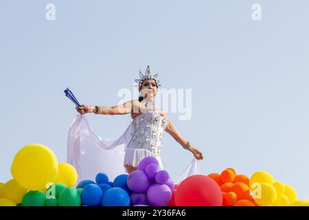 Goiânia GOIAS BRASILE - 08 SETTEMBRE 2024: Una persona LGBT, vestita di bianco con un galleggiante decorato con palloncini, ballando, alla LGBT Pride Parad del 2024 Foto Stock