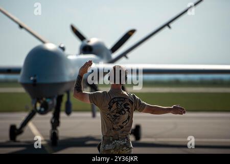 Un manutentore del 147th Attack Wing guida un mq-9 Reaper come taxi sulla linea di volo dopo l'atterraggio a Caslav, Cechia, il 3 settembre 2024. Il Foto Stock