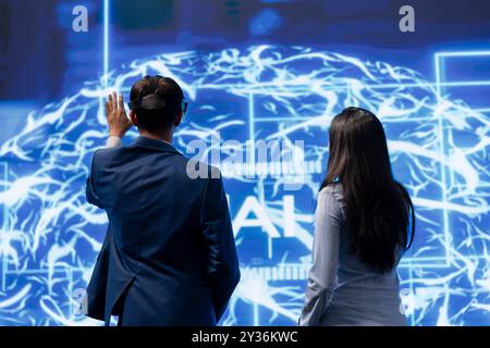 Gli ingegneri utilizzano il visore VR e le reti neurali ai modellate sul cervello umano per risolvere problemi complessi. Esperti IT che utilizzano l'intelligenza artificiale e la tecnologia della realtà virtuale per esaminare i dati Foto Stock