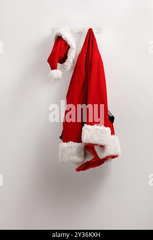 Costume e cappello di Babbo natale appesi su un muro Foto Stock