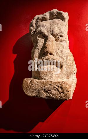 Bath, Inghilterra - 05-29-2024: Maschera teatrale scolpita in pietra locale di Bath, probabilmente da una grande tomba a Bath in Inghilterra. Il defunto potrebbe aver avuto un conn Foto Stock