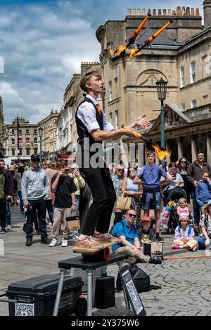 Bath; Inghilterra - 05-29-2024 : artista di strada, giocoliere e intrattenitore nella pittoresca città di Bath, Inghilterra. Giocoleria con bacchette fiammeggianti Foto Stock