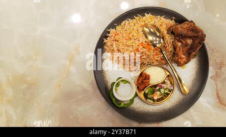 Riso kebuli (nasi kebuli) con cibo arabo sul tavolo con spazio vuoto accanto Foto Stock