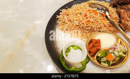 Riso Kebuli (nasi kebuli) primo piano, tipico cibo arabo sul tavolo con spazio vuoto accanto, dettaglio angolo superiore Foto Stock