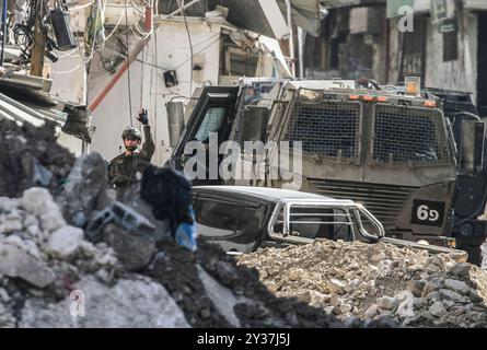 Tulakrm, Palestina. 12 settembre 2024. Il soldato israeliano ha visto sventolare la mano durante un raid dell'esercito israeliano a Tulkarm e nei suoi campi nel nord della Cisgiordania occupata. L'11 settembre il ministro della difesa israeliano Yoav Gallant ha affermato che i militari dovrebbero usare tutta la loro "forza” per colpire i militanti palestinesi nella Cisgiordania occupata, dove un'ampia operazione militare ha ucciso decine di persone. (Foto di Nasser Ishtayeh/SOPA Images/Sipa USA) credito: SIPA USA/Alamy Live News Foto Stock