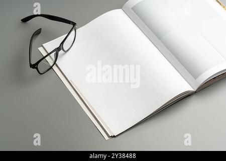 Un notebook vuoto aperto appoggiato su uno sfondo neutro durante il giorno Foto Stock