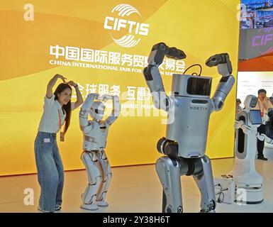 PECHINO, CINA - 13 SETTEMBRE 2024 - i visitatori posano con robot intelligenti alla China Beijing International Fair for Trade in Services 2024 (CIFTIS Foto Stock