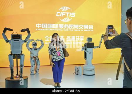 PECHINO, CINA - 13 SETTEMBRE 2024 - i visitatori posano con robot intelligenti alla China Beijing International Fair for Trade in Services 2024 (CIFTIS Foto Stock