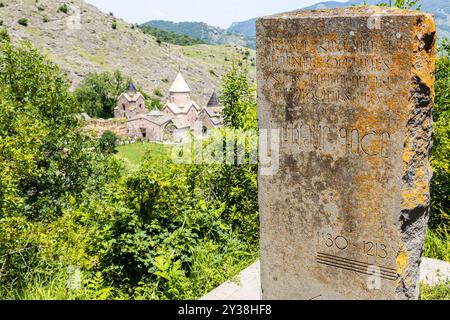 Osh, Armenia - 6 luglio 2024: Lapide nei pressi della Chiesa dell'Ascensione e vista del monastero di Goshavank nel villaggio di Gosh, Armenia, il giorno estivo di sole Foto Stock