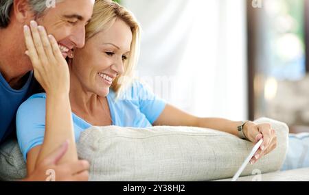 Coppia felice, romantico o tablet a casa per la scelta di film e lo streaming online sul divano del soggiorno. Amore, maturo o persone rilassate nella lounge on Foto Stock