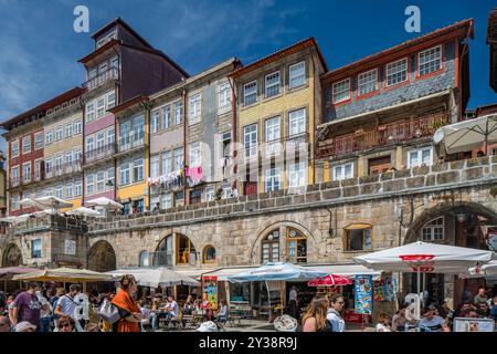 Porto, Portogallo, 15 aprile 2017, vivace scena di strada a Cais da Ribera a Porto, Portogallo. Le persone apprezzano i caffè all'aperto e l'architettura unica sotto un cl Foto Stock