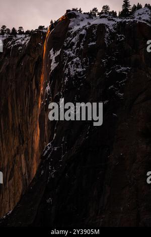 La cascata del fuoco di Yosemite, che si illumina sulla roccia innevata di El Capitan Foto Stock