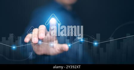 Concetto grafico di crescita di finanza, affari, investimenti o economia. Un uomo che tocca la parte superiore di una freccia, analizza i dati, mentre sale in alto. La cartella e. Foto Stock