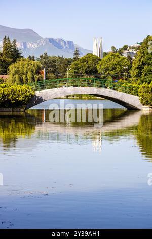 Vista del ponte pedonale sul laghetto artificiale della città di Dilijan nella soleggiata giornata estiva Foto Stock