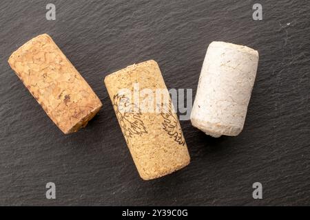 Tre tappi di sughero su ardesia, macro, vista dall'alto. Foto Stock