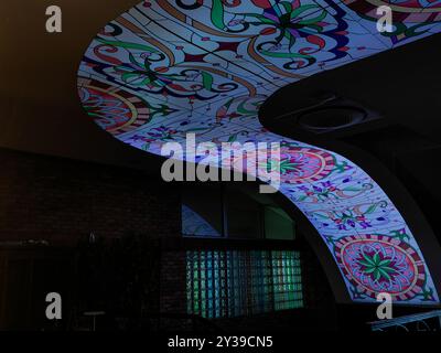 Moderno design a mosaico con soffitto a curva e finestre, ambiente scuro. Foto Stock