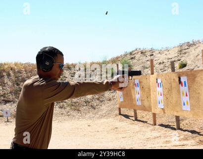 San Diego (31 maggio 2006) - il golfista professionista Tiger Woods tira fuori un round da una pistola durante l'allenamento in un poligono di tiro fuori San Diego. Gli ISTRUTTORI DI SEAL della Marina assegnati al Naval Special Warfare Center di Coronado hanno insegnato a Woods abilità di base di tiro durante una recente visita. U. S foto della Marina di Deborah Carson (PUBBLICATA) Foto Stock