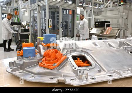 AMT Wachsenburg, Germania. 13 settembre 2024. Nino Sänn (r), dipendente della produzione, e Kay Hoschke (l), supervisore del turno, lavorano a un sistema il giorno dell'inaugurazione ufficiale di una nuova sala di produzione presso Marquardt Systronics GmbH. Il fornitore automobilistico produce sistemi di gestione delle batterie in Turingia. Crediti: Martin Schutt/dpa/Alamy Live News Foto Stock