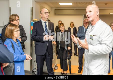 13 settembre 2024, Brandeburgo, Cottbus: Tim Flasbeck (r), medico capo della clinica di pronto soccorso presso l'Università medica della Lusazia - Carl Thiem (MUL-CT) parla con Ursula Nonnemacher (Alleanza 90/Verdi), Ministro degli affari sociali, della salute, dell'integrazione e della protezione dei consumatori e Dietmar Woidke (SPD), Ministro Presidente dello Stato di Brandeburgo. Il pronto soccorso più moderno in Germania apre oggi nel campus MUL-CT. Il nuovo pronto soccorso ha un totale di 40 posti di trattamento e 45 posti in una zona di attesa. Ciò significa che è teoricamente possibile trattare 50 pazienti Foto Stock