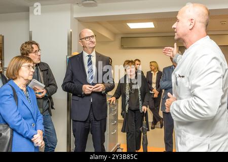 13 settembre 2024, Brandeburgo, Cottbus: Tim Flasbeck (r), medico capo della clinica di pronto soccorso presso l'Università medica della Lusazia - Carl Thiem (MUL-CT) parla con Ursula Nonnemacher (Alleanza 90/Verdi), Ministro degli affari sociali, della salute, dell'integrazione e della protezione dei consumatori e Dietmar Woidke (SPD), Ministro Presidente dello Stato di Brandeburgo. Il pronto soccorso più moderno in Germania apre oggi nel campus MUL-CT. Il nuovo pronto soccorso ha un totale di 40 posti di trattamento e 45 posti in una zona di attesa. Ciò significa che è teoricamente possibile trattare 50 pazienti Foto Stock