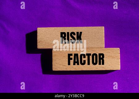 Messaggio sul fattore di rischio scritto su blocchi di legno con sfondo viola. Simbolo del fattore di rischio concettuale. Copia spazio. Foto Stock