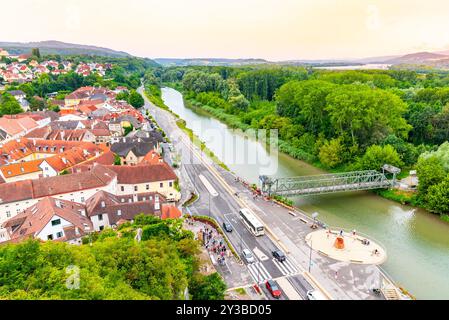 Vista aerea della città di Melk con il fiume Danubio che scorre lungo le rive verdeggianti del fiume e un vivace ponte durante una luminosa giornata estiva. Foto Stock