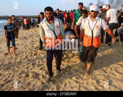 10 palestinesi su una flottiglia di dozzine di navi navali lanciate dalla città di Gaza sono stati feriti dal fuoco della marina israeliana dopo essersi avvicinati al confine marittimo al largo della costa di Gaza. Decine di manifestanti palestinesi sono stati feriti anche da colpi di arma da fuoco israeliani e gas lacrimogeni durante una manifestazione sulla costa vicino a Gaza City. L'evento è stato organizzato dall'alta Commissione Nazionale della grande marcia del ritorno e della rottura dell'assedio di Gaza, che è stato tentato di rompere il blocco di undici anni dell'enclave palestinese. La flottiglia partì dal porto di Gaza dirigendosi verso le acque israeliane. Alcuni di Foto Stock