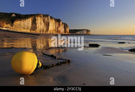 Scogliere di gesso della costa di Alabaster alla luce della sera, di fronte a una boa gialla sulla spiaggia con la bassa marea, Cote d'Albatre, Les Petites Dalles, norma Foto Stock