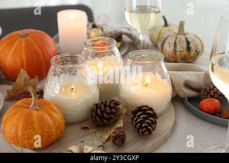 Candele accese e decorazioni autunnali sul tavolo, primo piano Foto Stock