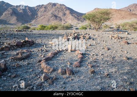 Antica tomba musulmana nei monti Hajar, delimitata da pietre, che rappresenta un legame culturale con il passato e le sacre pratiche di sepoltura dell'antico Foto Stock