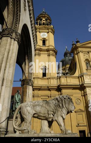 Leone di pietra di fronte alla Feldherrnhalle e alla Chiesa Teatina di Monaco Foto Stock