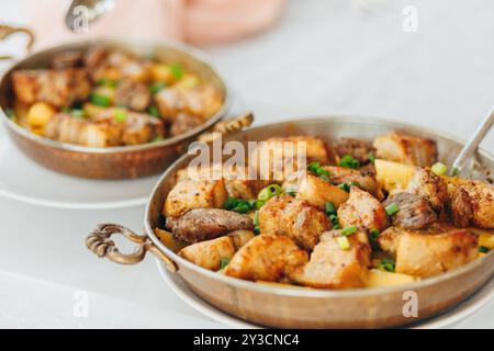 Maiale alla griglia con cipolla e champignon, servito con patate al forno. Foto Stock