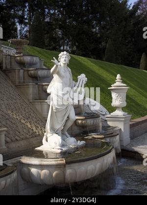 Classica statua in marmo accanto a una fontana ornata e gradini nel giardino, Apeldoorn, Paesi Bassi Foto Stock